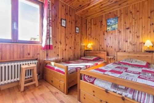 deux lits dans une chambre aux murs en bois dans l'établissement Résidence Les Chavonnes - Appartement 2 pièces de 43m² pour 5/6 personnes MAE-7824, à Montvalezan