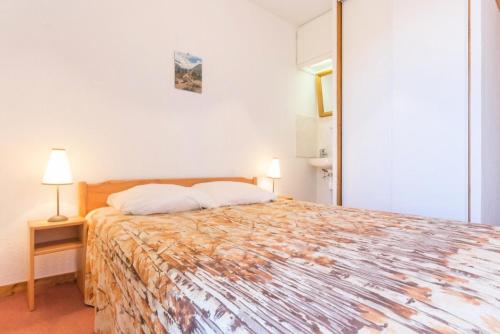 une chambre avec un grand lit et deux lampes dans l'établissement Résidence Les Niverolles - Appartement 2 pièces,coin montagne, de 30m²,6 pers MAE-8084, à Montvalezan