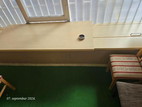 a room with a desk with two chairs and a green floor at Laki 15 in Kalugjerica