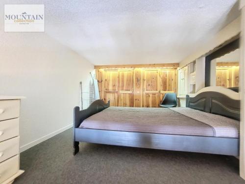 une chambre avec un lit avec des armoires en bois et une commode dans l'établissement Résidence Bouquetins A - Appartement 2 pièces de 40m² pour 6 personnes MAE-8104, à Montvalezan