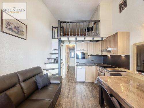 un salon avec un canapé et une cuisine dans l'établissement Résidence Bouquetins A - Appartement 2 pièces de 40m² pour 6 personnes MAE-8104, à Montvalezan