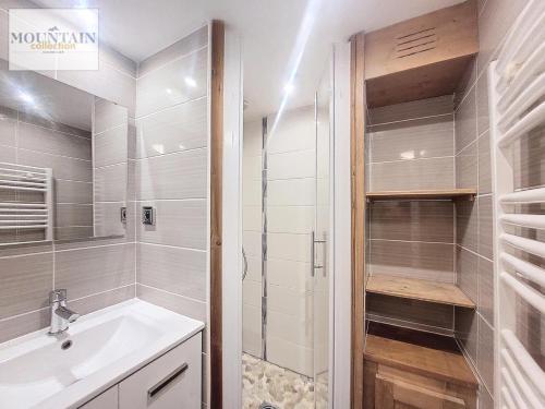 une salle de bain blanche avec un lavabo et une douche dans l'établissement Résidence Bouquetins A - Appartement 2 pièces de 40m² pour 6 personnes MAE-8104, à Montvalezan