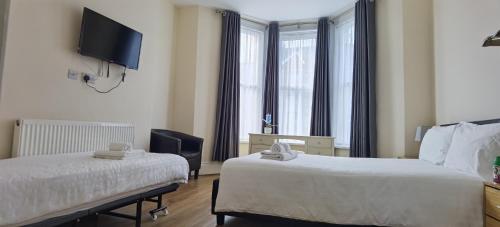 a hotel room with two beds and a flat screen tv at Entire 2 bedroom Apt in central location, Newly Refurbished in Plymouth