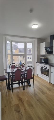 a kitchen with a table and chairs in a room at Comfy 2 bedroom Apt in central location, Newly Refurbished in Plymouth