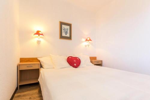 - une chambre avec un lit doté d'un oreiller à cœur rouge dans l'établissement Résidence La Vanoise - Appartement 2 pièces de 50m² pour 6 personnes MAE-8164, à Montvalezan