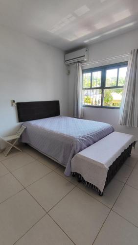 a bedroom with a large bed and a window at Ótimo e bem localizado - Centro do Mar Grosso - Laguna in Laguna