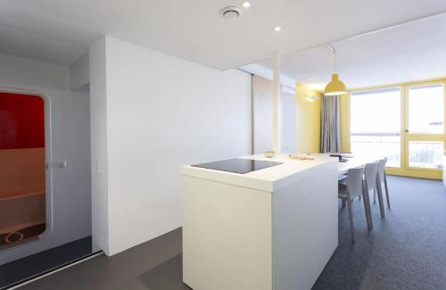 eine Küche mit einer weißen Theke und einem Tisch mit Stühlen in der Unterkunft Résidence Varet 2 - Appartement rénové 3 pièces 7 personnes MAE-7854 in Arc 2000