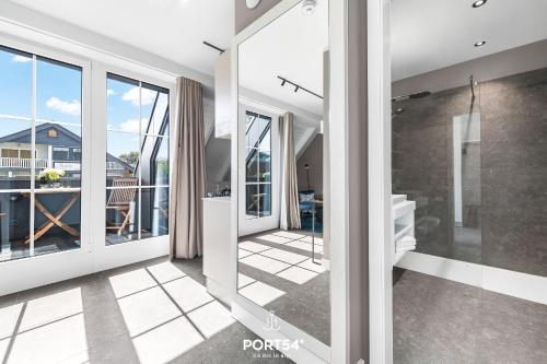 a bathroom with sliding glass doors and a balcony at Ferienwohnung Erholen St Peter Ording in Böhl