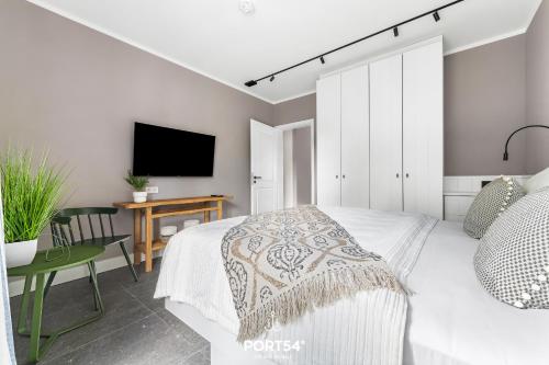 a bedroom with a bed and a desk and a tv at Ferienwohnung Entspannen St Peter Ording in Böhl
