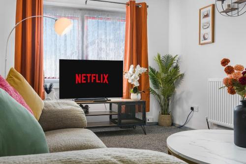 a living room with a tv with the netflix sign on it at Villa Casa in Birmingham