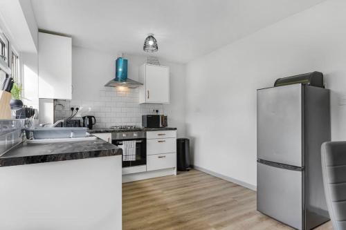 a kitchen with white cabinets and a stainless steel refrigerator at Villa Casa in Birmingham