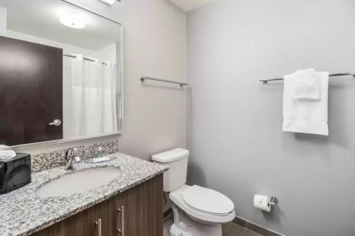 a bathroom with a sink and a toilet and a mirror at MainStay Suites Union City, TN in Union City