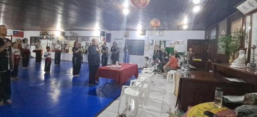 a group of people standing in a room with a table at Pousada Taiwan in Ubatuba