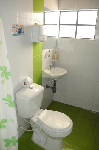 アキタニアにあるHotel Guaquira Realの白いトイレと洗面台のあるバスルーム