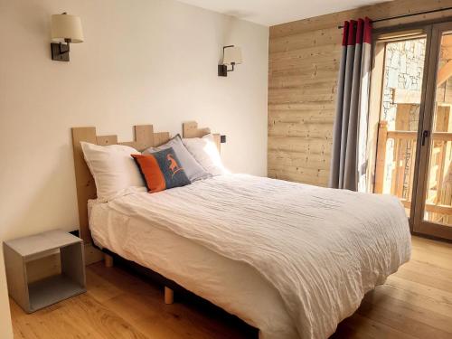 une chambre avec un grand lit et une fenêtre dans l'établissement Résidence Diamant Des Cimes - Appartement Haute Gamme avec vue sur la vallée MAE-3264, à Montvalezan