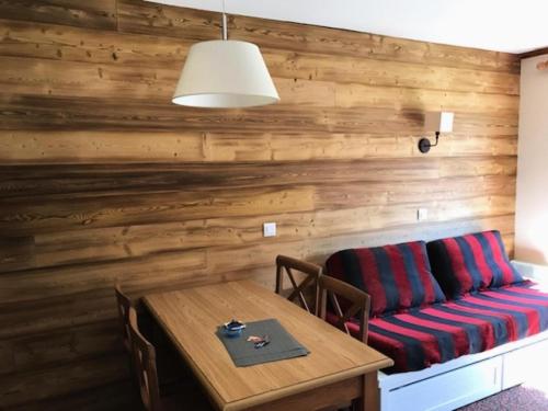 Cette chambre est dotée d'un mur en bois avec un banc et une table. dans l'établissement Résidence Alpaga - Appartement lumineux · Proche des pistes · Parking extérieur MAE-8414, à La Salle Les Alpes
