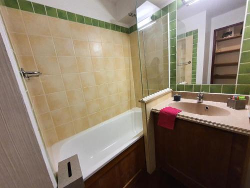une salle de bain avec un lavabo, une baignoire et un miroir dans l'établissement Résidence Alpaga - Appartement lumineux · Proche des pistes · Parking extérieur MAE-8414, à La Salle Les Alpes