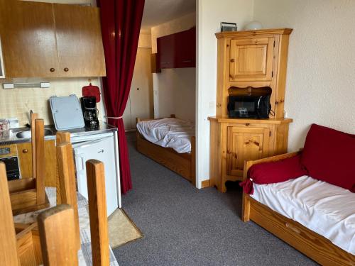 une petite chambre avec deux lits et une cuisine dans l'établissement Le Valesclo au Chamois, à Risoul