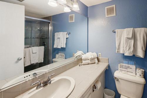 Un baño con lavabo, inodoro y espejo. en La Internacional Condominiums #202, en South Padre Island
