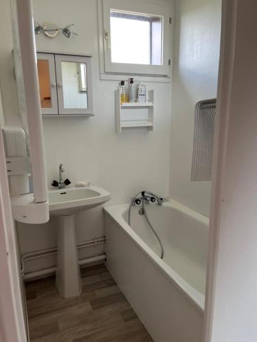 La salle de bains blanche est pourvue d'un lavabo, d'une baignoire et d'un lavabo. dans l'établissement Le Valesclo au Chamois, à Risoul