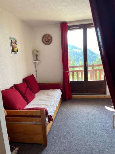 une chambre avec un lit et une grande fenêtre dans l'établissement Le Valesclo au Chamois, à Risoul