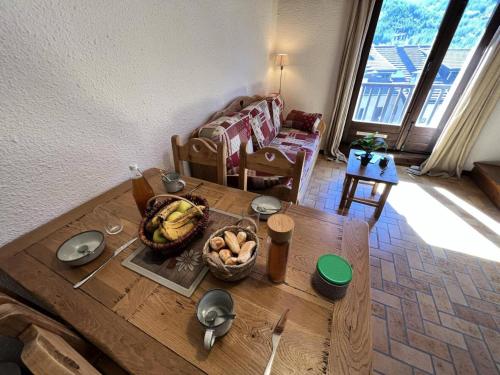 - un salon avec une table et un panier de bananes dans l'établissement Résidence Vie De Clare Narcisse - Appartement chaleureux · Centre village · Cheminée MAE-0164, au Monêtier-les-Bains