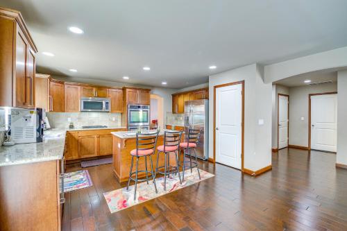 a kitchen with wooden cabinets and bar stools at Family-Friendly Home with Patio and Garden in Everett! in Everett