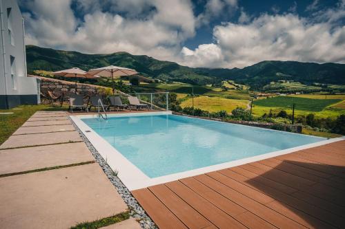 a swimming pool with a view of a mountain at Benilde Village House in Povoação