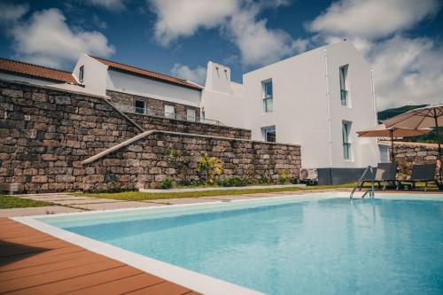 a swimming pool in front of a house at Benilde Village House in Povoação