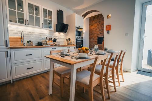a kitchen with a wooden table and chairs in a room at Benilde Village House in Povoação