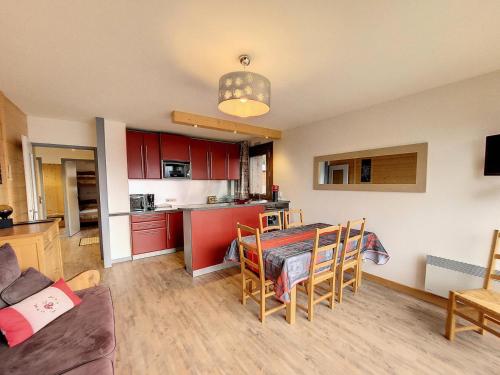 une cuisine et un salon avec une table et des chaises dans l'établissement Résidence Les Alpages - Appartement chaleureux et lumineux · Centre station · Balcon MAE-5374, à Montvalezan
