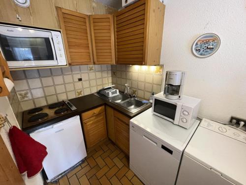 une petite cuisine avec un évier et un micro-ondes dans l'établissement Résidence Gardiole 3 - Appartement · Centre village · Vue montagne MAE-4144, au Monêtier-les-Bains