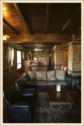 a living room with a leather couch and a table at Voreas Hotel in Kato Loutraki