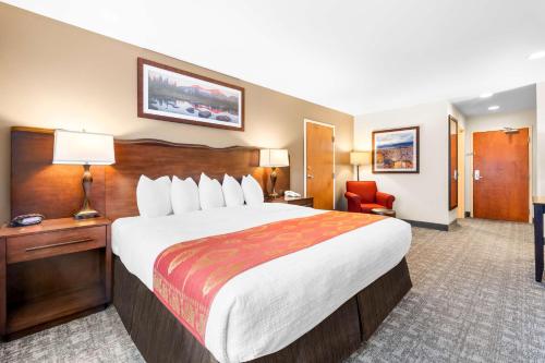 a hotel room with a large bed and a chair at Best Western Rocky Mountain Lodge in Whitefish