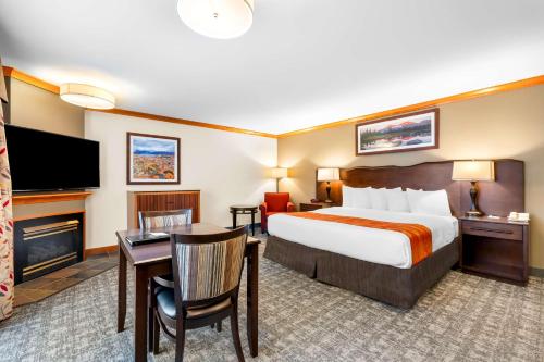 a hotel room with a bed and a desk and a television at Best Western Rocky Mountain Lodge in Whitefish