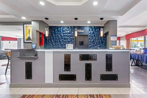 a lobby with a bar with a blue wall at Best Western Inn at the Rochester Airport in Rochester