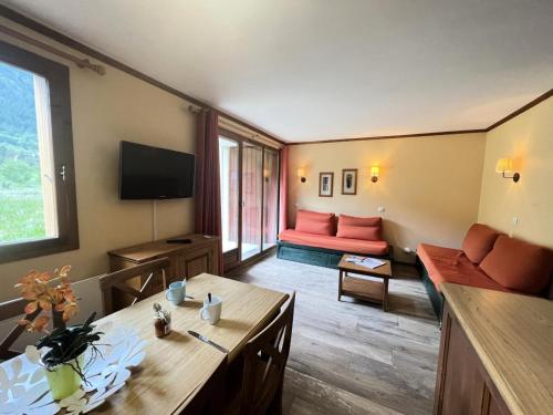 un salon avec un canapé et une table dans l'établissement Résidence Alpaga - Appartement chaleureux · Proche des pistes · Parking couvert & casier à skis MAE-9004, à La Salle Les Alpes