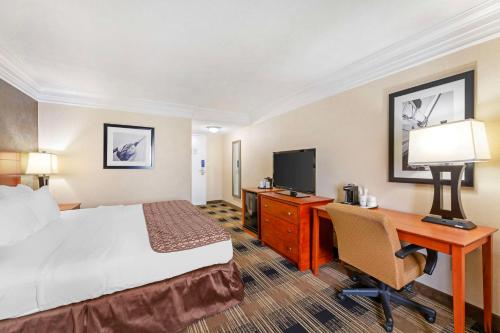 a hotel room with a bed and a desk and a computer at Best Western Inn at the Rochester Airport in Rochester