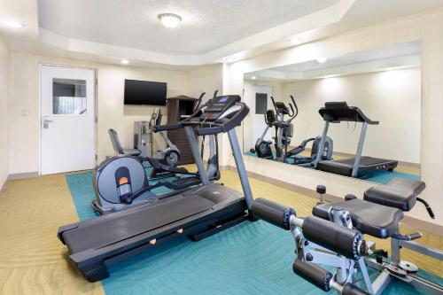 a gym with three tread machines in a room at Best Western Inn at the Rochester Airport in Rochester