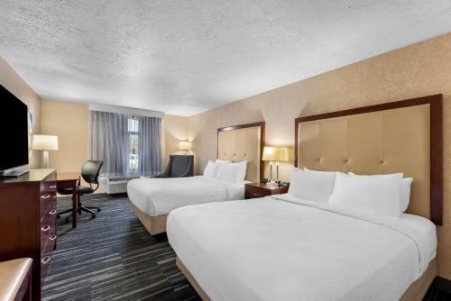 a hotel room with two beds and a flat screen tv at Best Western Plus Abbey Inn in St. George