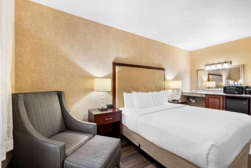 a hotel room with a bed and a chair at Best Western Plus Abbey Inn in St. George