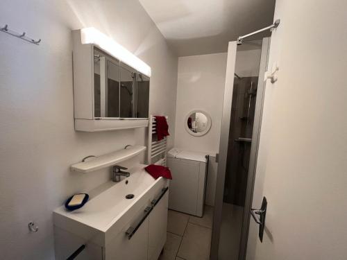 une salle de bain blanche avec un lavabo et une douche dans l'établissement Résidence Concorde V - Grand studio · lumineux · rénové MAE-4034, à La Salle Les Alpes