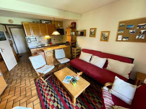 un salon avec un canapé rouge et une table dans l'établissement Résidence Gardiole 4 - Appartement chaleureux · Centre village · Cheminée MAE-1614, au Monêtier-les-Bains