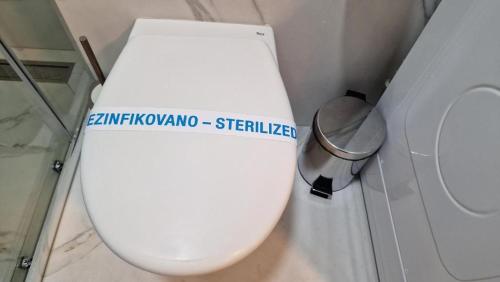 a white toilet in a bathroom with a trash can at LUXURY APARTMAN ELENI ROOMS oaza mira i tišine u centru Vrnjačke banje in Vrnjačka Banja