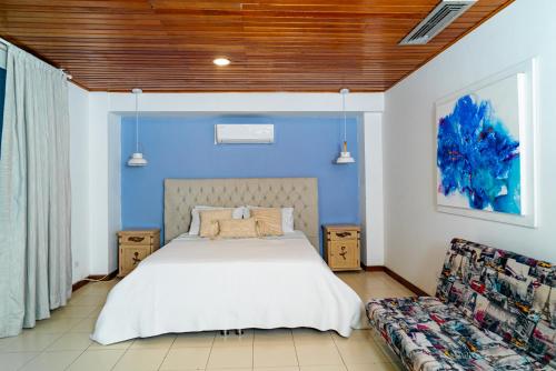 une chambre avec un lit et un mur bleu dans l'établissement Amplia habitación con vista al mar y baño privado, à Carthagène des Indes