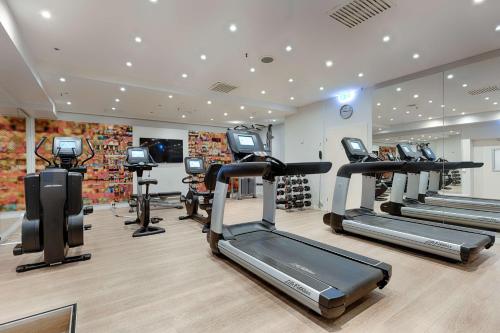 a gym with several tread machines in a room at Park Inn by Radisson Berlin Alexanderplatz in Berlin