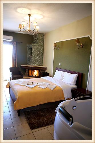 a hotel room with a large bed and a fireplace at Voreas Hotel in Kato Loutraki