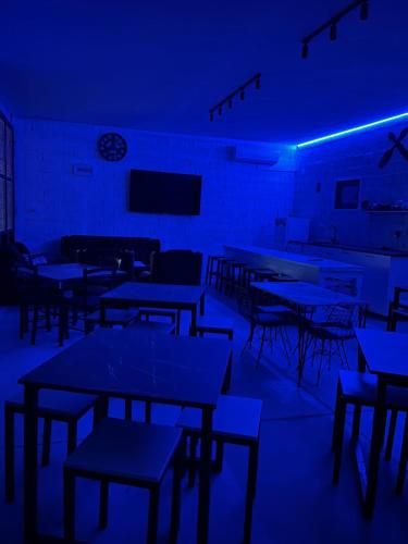 an empty room with tables and chairs in blue lights at Lokal za zurke, slavlja i rodjendane in Pećinci