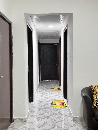 a hallway with a black door and a tile floor at Cozy STAY in Abu Dhabi