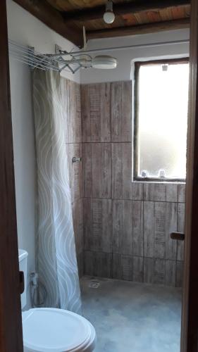 a bathroom with a shower with a toilet and a window at Chalé Temático Mata Atlântica in Paraty